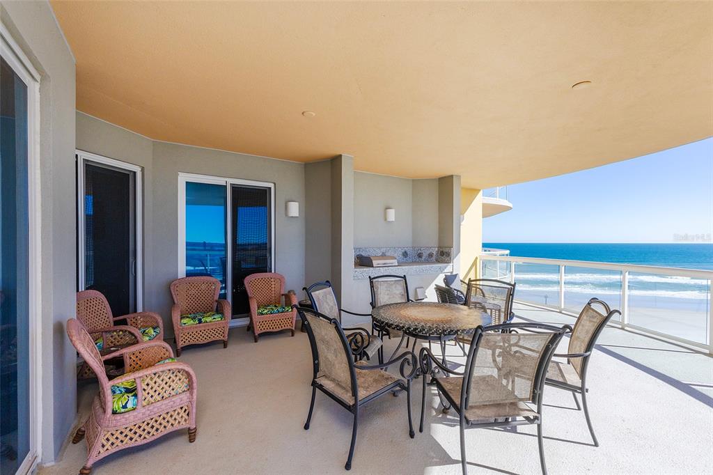 A spacious balcony features wicker and metal patio furniture, a built-in grill, and ocean views — 3703 S ATLANTIC AVENUE UNIT 505, DAYTONA BEACH SHORES, FL