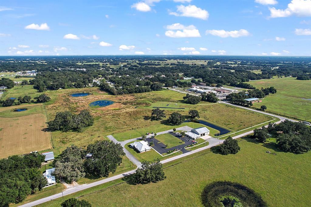 An aerial view shows a rural property with two buildings, parking lots, and several ponds — 416 S MARKET BOULEVARD, WEBSTER, FL