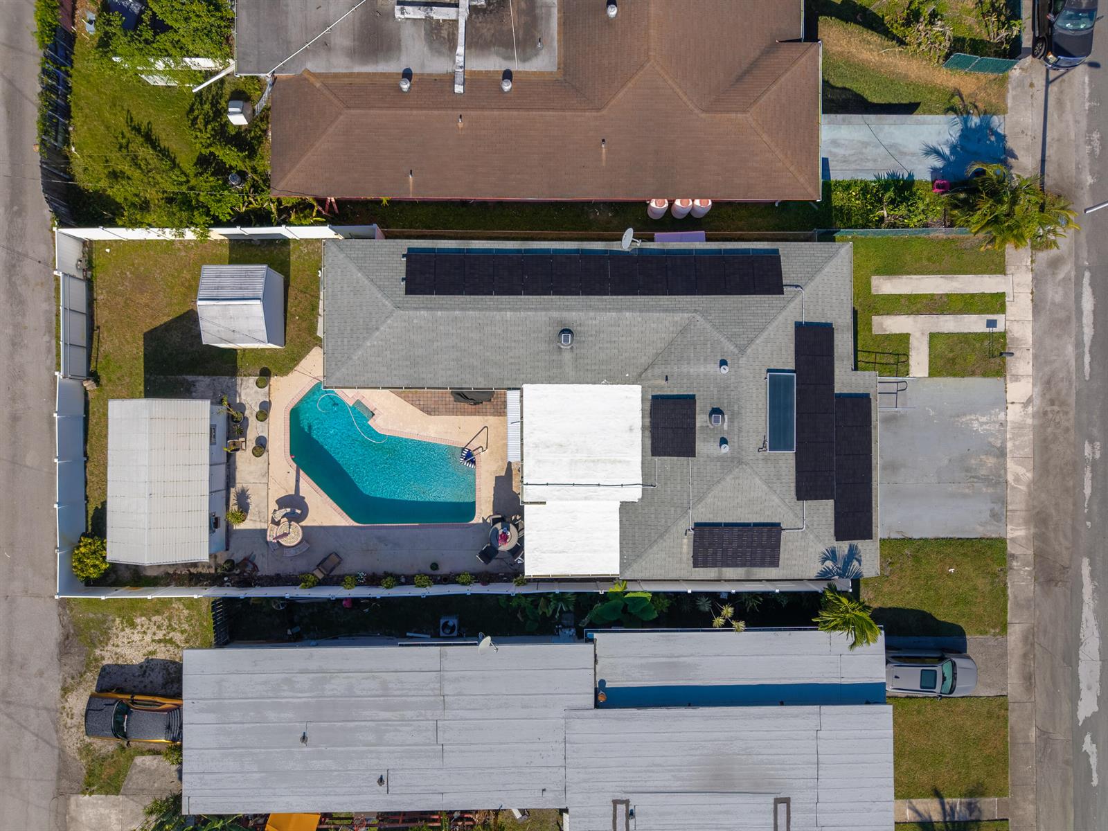 An aerial view shows a house with a swimming pool, solar panels, and a white roof — 262 SW 8th Street, Dania Beach FL 33004, DANIA BEACH, FL