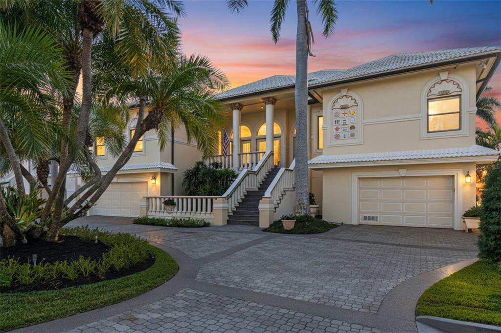 A two-story house with a paved driveway, palm trees, and a raised front entrance — 964 MONTE CRISTO BOULEVARD, TIERRA VERDE, FL