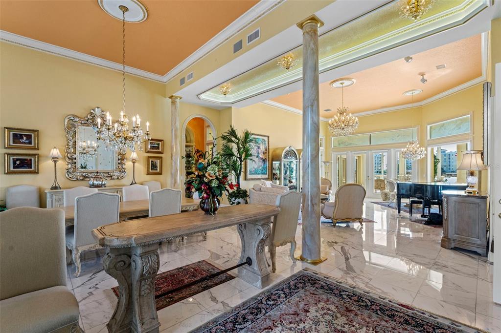 A formal dining room and living area feature marble floors, columns, and ornate chandeliers — 964 MONTE CRISTO BOULEVARD, TIERRA VERDE, FL