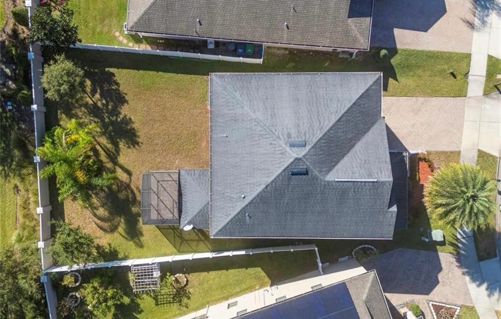 An aerial view shows a house with a dark shingled roof and a screened-in patio — 12273 GREAT COMMISSION WAY, ORLANDO, FL