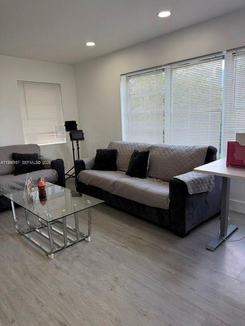 A living room features a gray sofa, a glass coffee table, and windows with blinds — 821 NE 6th St # 2, Hallandale Beach FL 33009, HALLANDALE BEACH, FL