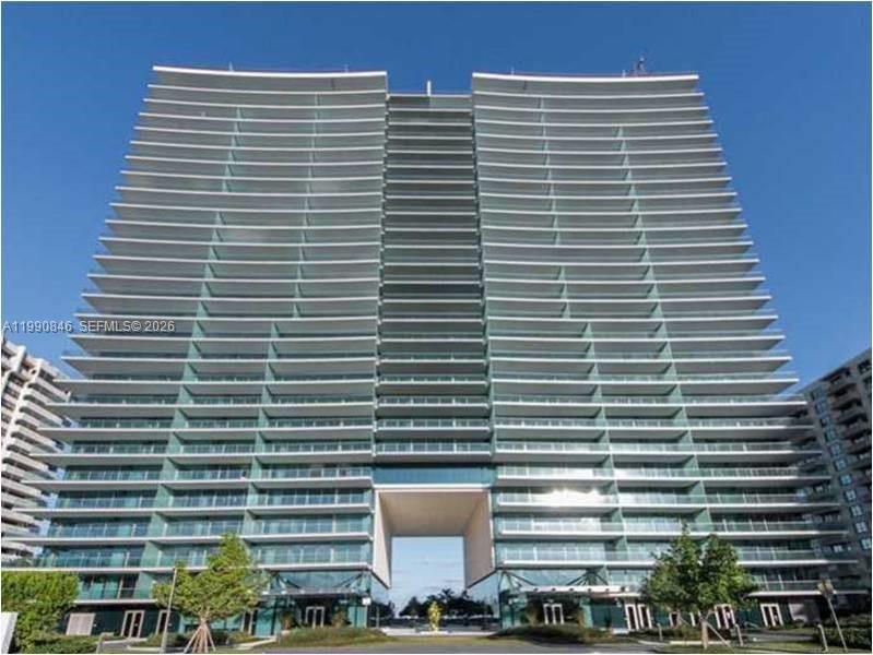 A modern high-rise residential building features a central breezeway and extensive glass balconies — 10203 Collins Ave # 905, Bal Harbour FL 33154, BAL HARBOUR, FL