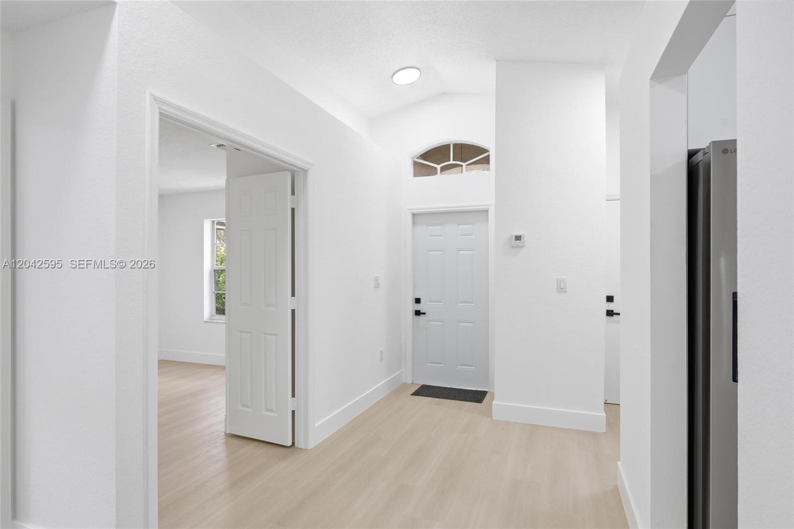 An entryway features white walls, light wood-look flooring, a front door, and an arched transom — 4114 Sapphire St, Weston FL 33331, WESTON, FL
