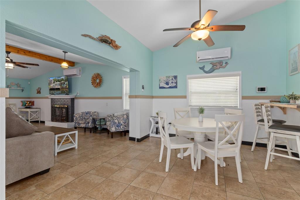 A living and dining area features light blue walls, tile floors, and a ceiling fan — 6245 WAVERLY ROAD, WEEKI WACHEE, FL