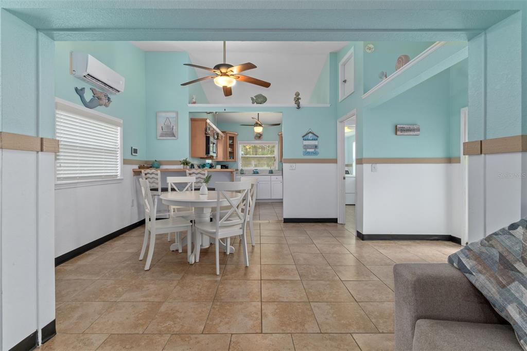 A dining area with a round table and chairs sits in front of an open kitchen — 6245 WAVERLY ROAD, WEEKI WACHEE, FL