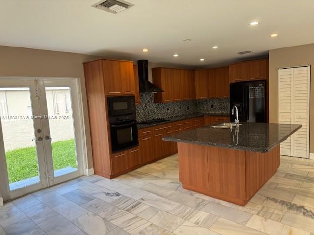A kitchen features wood cabinets, a granite-topped island, and glass doors leading to a yard — 200 NE 44th St # 0, Miami FL 33137, MIAMI, FL