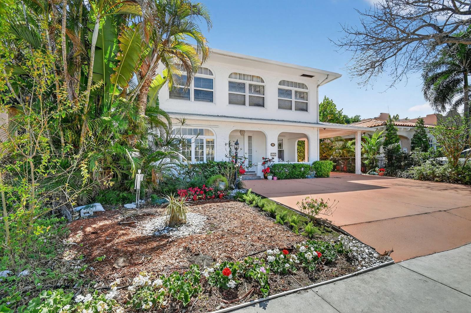 A two-story white house with arched windows and a paved driveway sits behind a garden — 328 Monroe Drive, West Palm Beach FL 33405, WEST PALM BEACH, FL