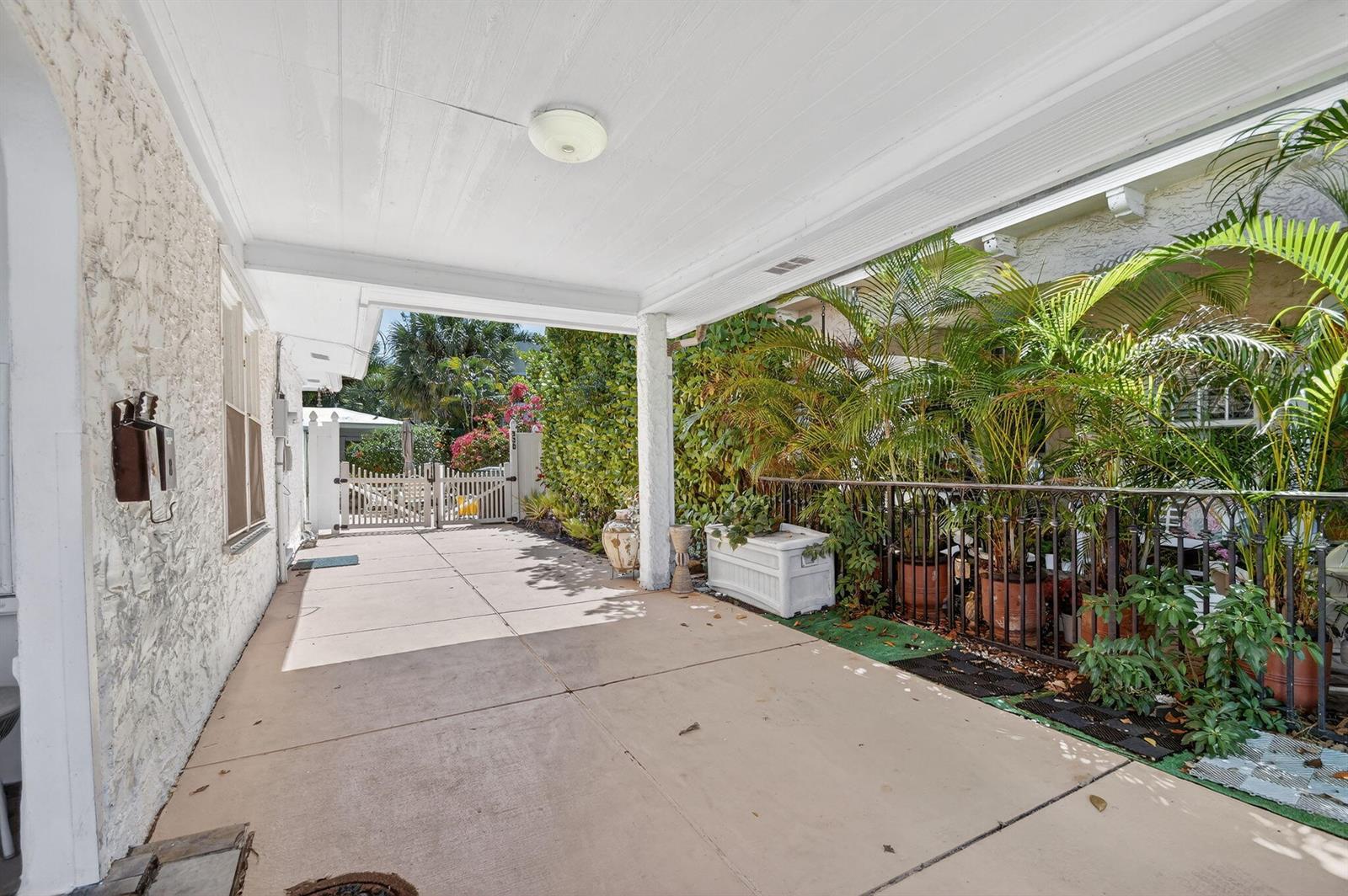 A covered concrete patio features a white ceiling, a support column, and potted palm plants — 328 Monroe Drive, West Palm Beach FL 33405, WEST PALM BEACH, FL