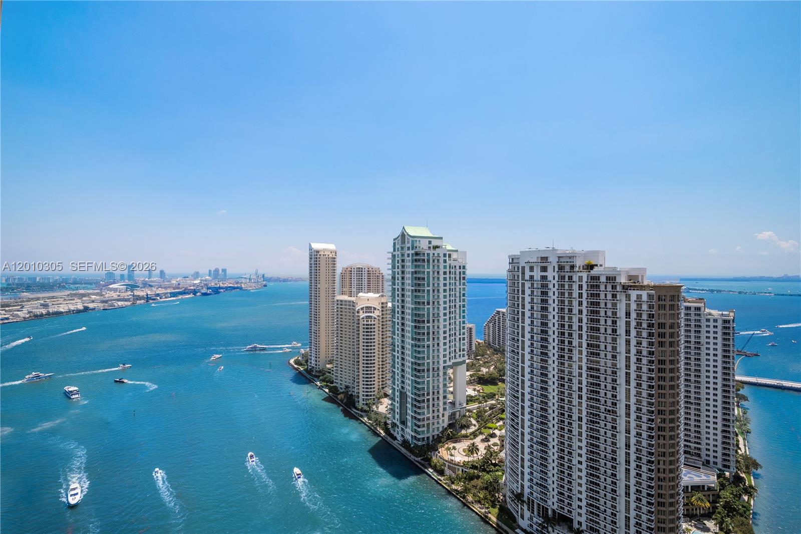An aerial view shows high-rise residential buildings situated along a blue waterway with boats — 300 Biscayne Blvd Way # 3503C, Miami FL 33131, MIAMI, FL