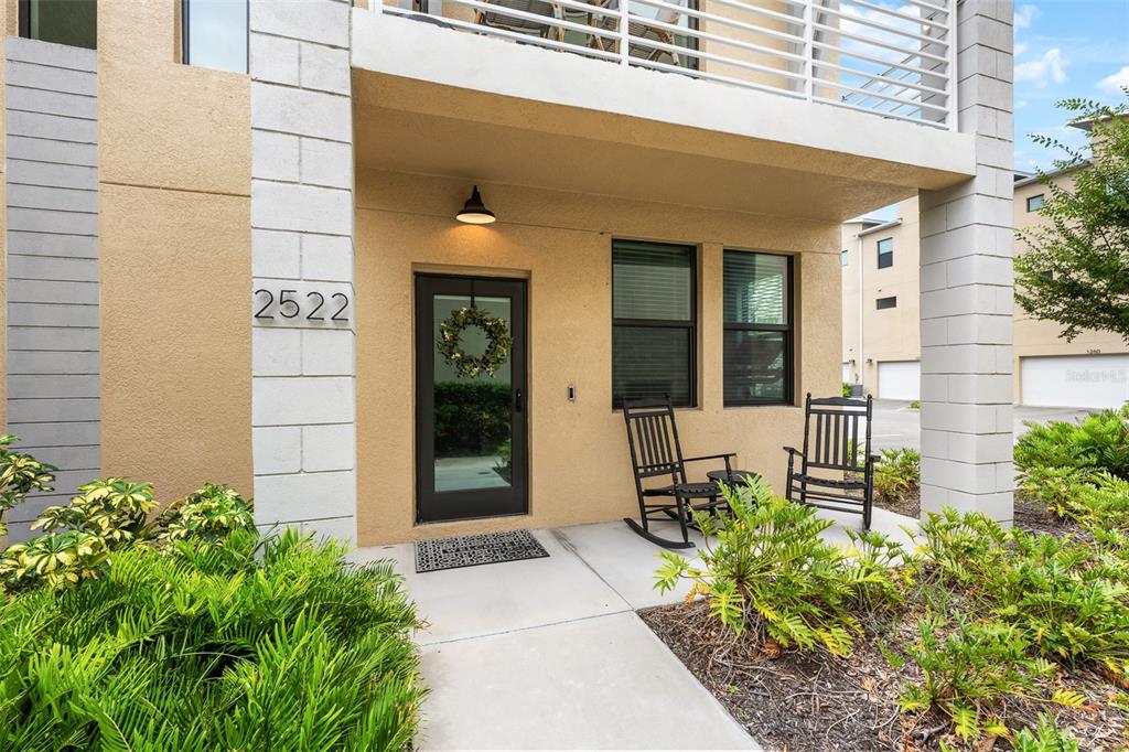 The exterior of a modern home features a front porch with two rocking chairs — 2522 12TH TERRACE N, ST PETERSBURG, FL