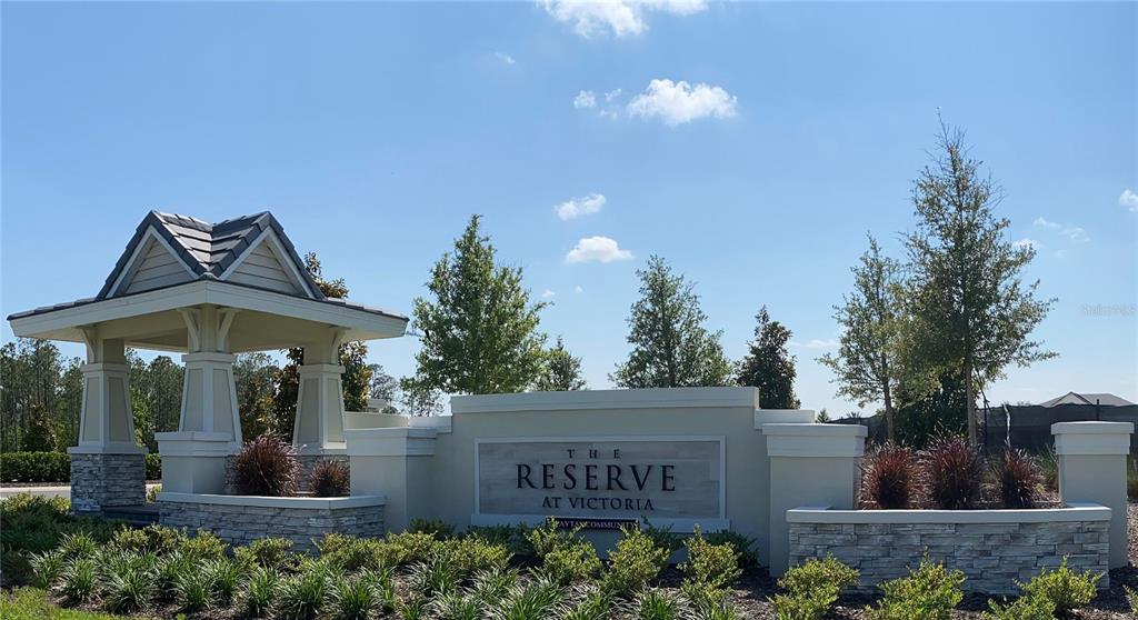 A stone and stucco entrance sign for The Reserve at Victoria stands under a blue sky — 1664 LAKE RESERVE DRIVE, DELAND, FL