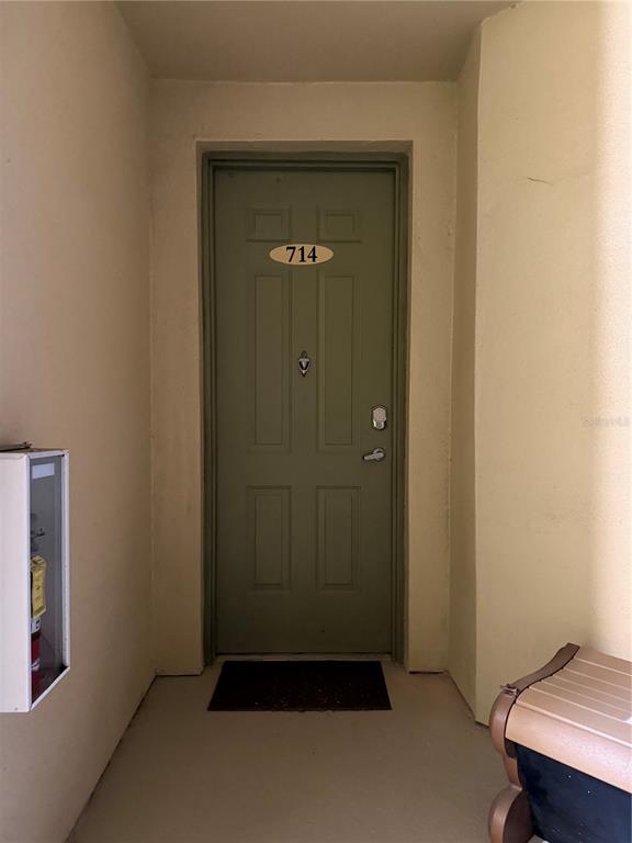 An exterior view of a green apartment door numbered 714 with a fire extinguisher cabinet — 714 TERRACE RIDGE CIRCLE UNIT 714, DAVENPORT, FL