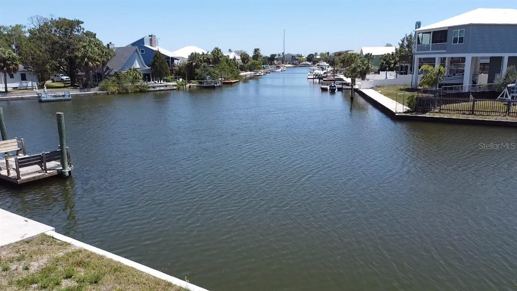 A canal view shows houses along the banks with private docks and moored boats — 4018 EAGLE NEST DRIVE, HERNANDO BEACH, FL