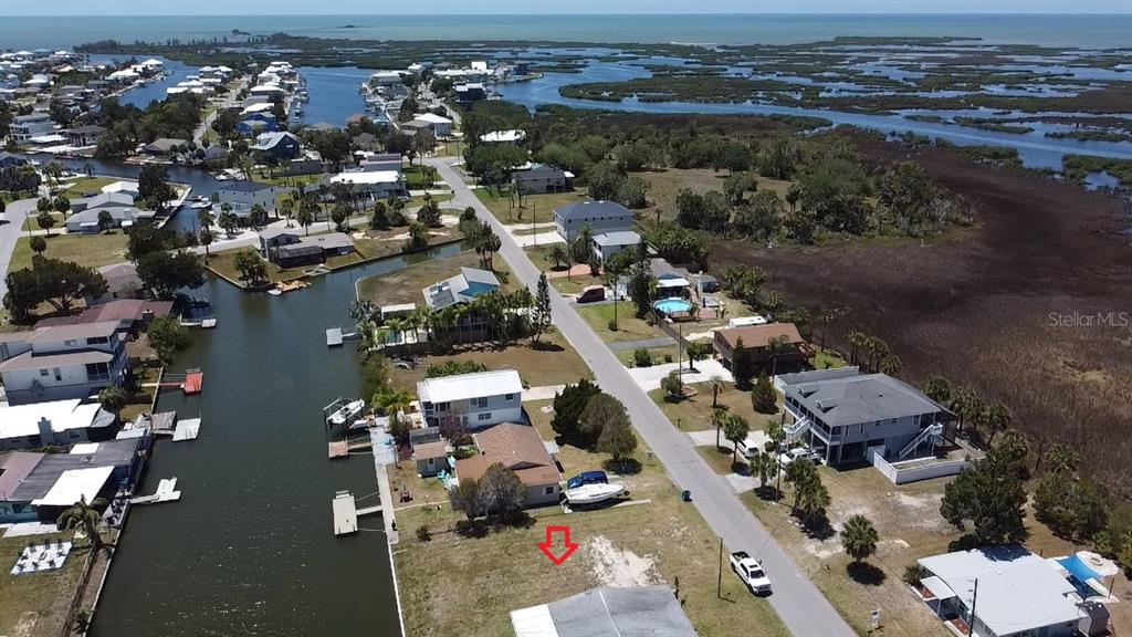An aerial view shows a waterfront residential lot with a house and boat dock — 4018 EAGLE NEST DRIVE, HERNANDO BEACH, FL