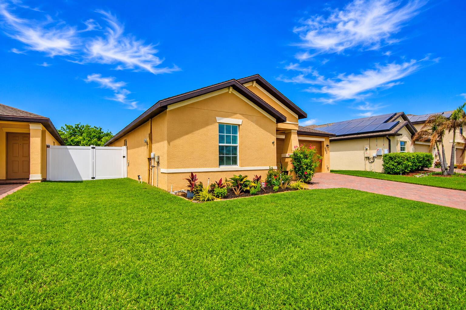 A single-story yellow stucco house with a brick driveway and a green lawn — 4242 Thurso Way, Fort Pierce FL 34947, FORT PIERCE, FL