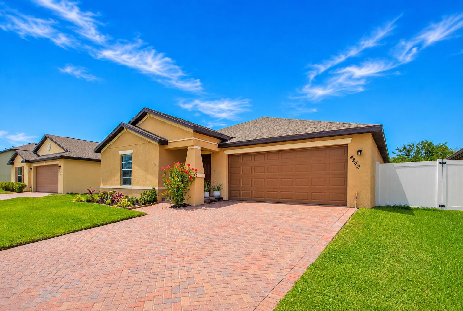 A single-story house with a brick paver driveway, tan stucco exterior, and a two-car garage — 4242 Thurso Way, Fort Pierce FL 34947, FORT PIERCE, FL