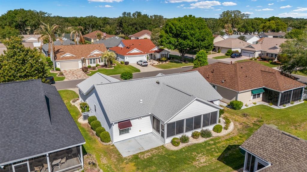 An aerial view shows the back of a light-colored house with a screened-in porch — 17637 SE 80TH ALTAMAHA COURT, THE VILLAGES, FL