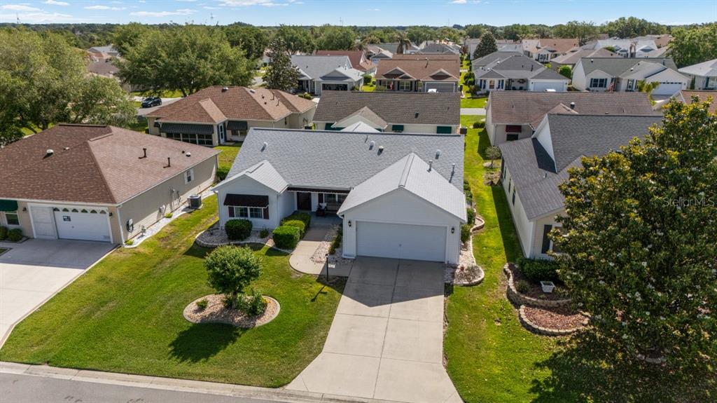 An aerial view shows a suburban house with a gray roof and a concrete driveway — 17637 SE 80TH ALTAMAHA COURT, THE VILLAGES, FL