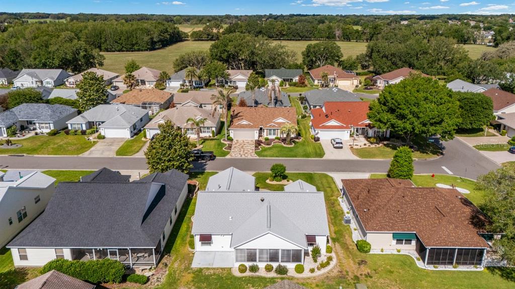 An aerial view shows several suburban houses with shingled roofs and green lawns — 17637 SE 80TH ALTAMAHA COURT, THE VILLAGES, FL