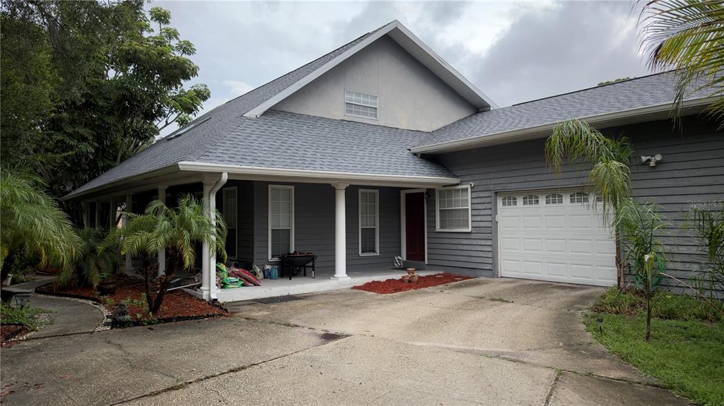 A kitchen features knotty pine cabinets, tile backsplash, white appliances, and a stainless steel dishwasher — 6451 76TH TERRACE N, PINELLAS PARK, FL