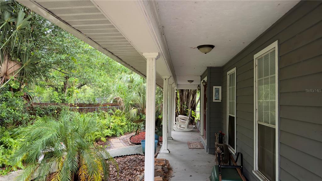 A living room with tile floors, a ceiling fan, and an open kitchen with wooden cabinets — 6451 76TH TERRACE N, PINELLAS PARK, FL