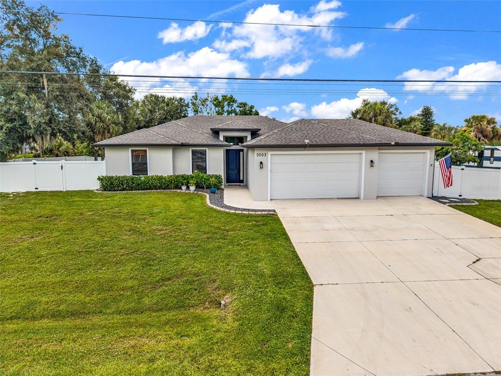 A single-story house with a gray exterior, a three-car garage, and a white privacy fence — 3503 LAVILLA AVENUE, NORTH PORT, FL