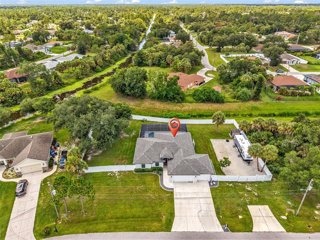 An aerial view shows a single-story house with a pool cage, driveway, and RV parking — 3503 LAVILLA AVENUE, NORTH PORT, FL