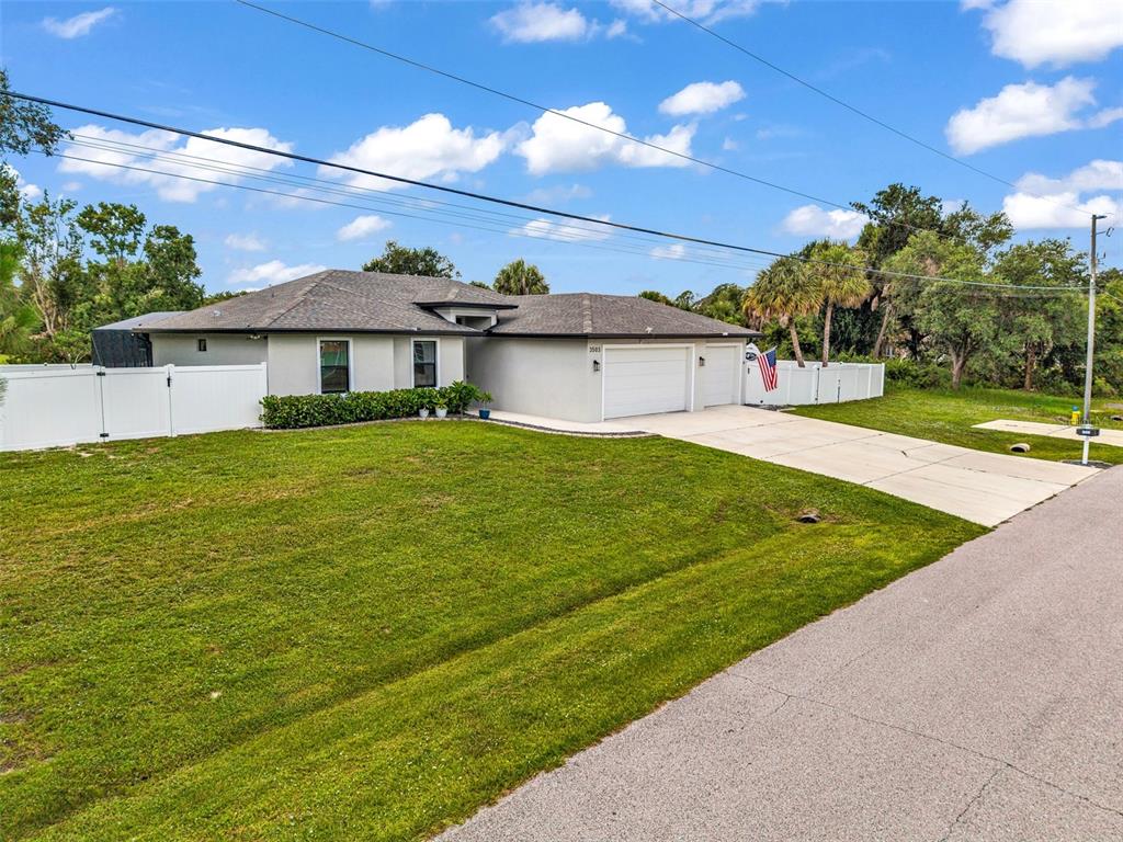 A single-story house with a gray exterior, a two-car garage, and a white vinyl fence — 3503 LAVILLA AVENUE, NORTH PORT, FL