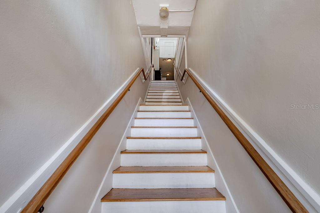 A straight staircase with white risers and wood treads leads to an upper landing — 440 N DONNELLY STREET, MOUNT DORA, FL