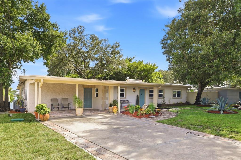 A single-story house with a covered front porch, concrete driveway, and mature trees — 6714 NINA ROSA DRIVE, ORLANDO, FL