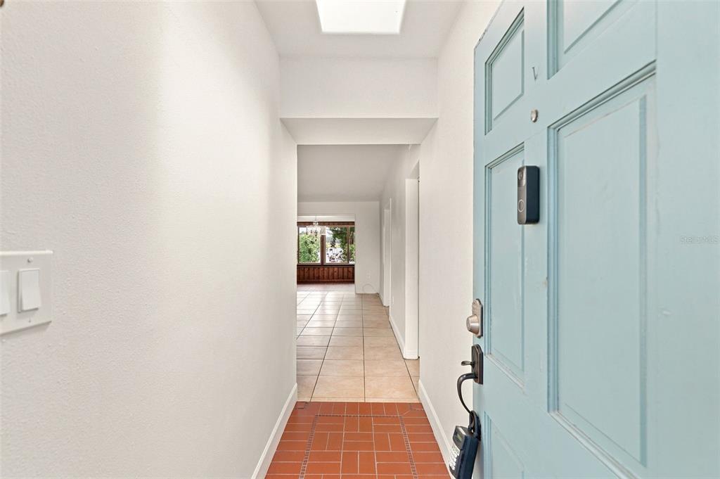 A light blue front door opens into a tiled entryway leading to a living area — 6714 NINA ROSA DRIVE, ORLANDO, FL