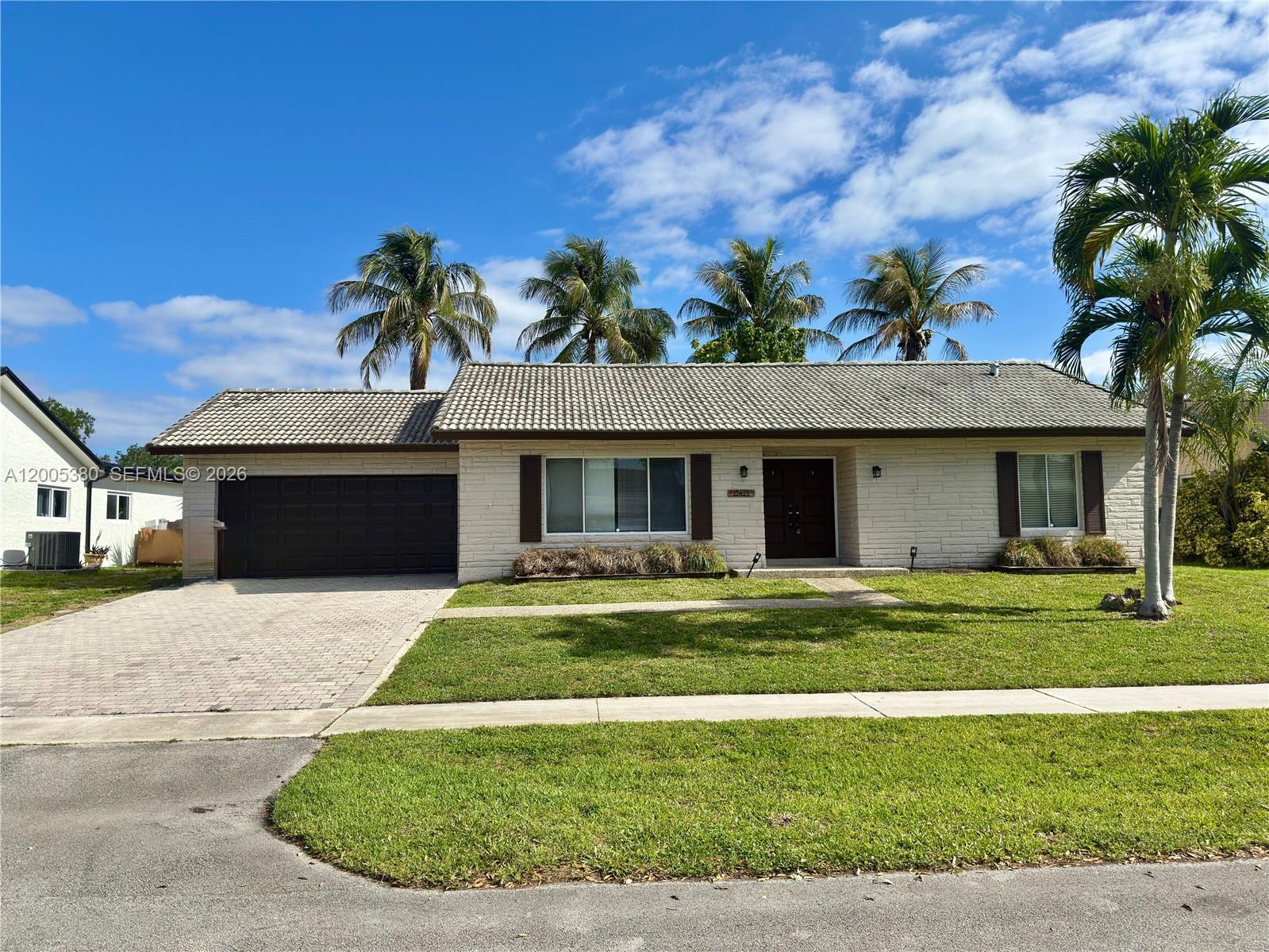 A single-story house with a tiled roof, brick exterior, and palm trees in the front yard — 13425 NW 10th St, Sunrise FL 33323, SUNRISE, FL