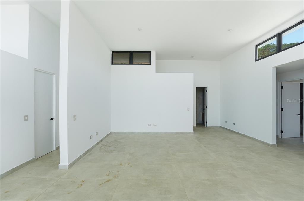 An empty room with white walls, high ceilings, large windows, and light-colored tile flooring — Monte azul MONTEAZUL, GUAYNABO, PR