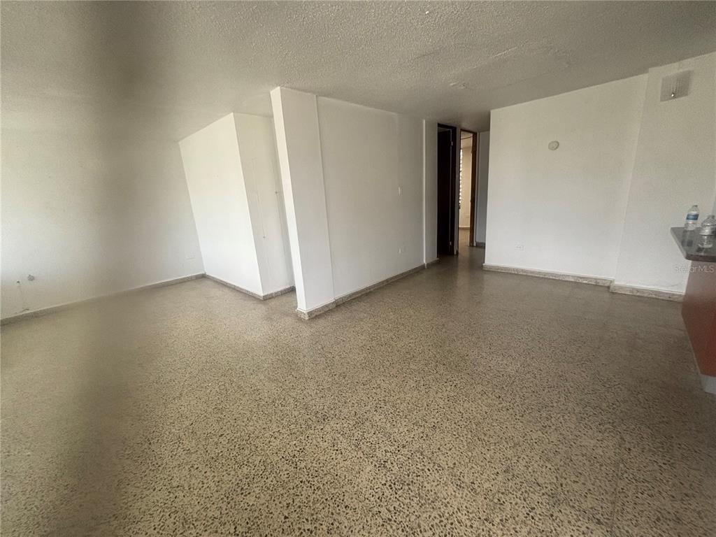 An empty room with white walls and speckled terrazzo flooring — Calle 18 BLOQUE 23, BAYAMON, PR