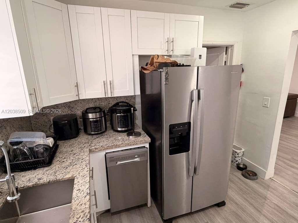 A kitchen features white cabinets, granite countertops, stainless steel appliances, and a dishwasher — 2920 SW 15th St, Miami FL 33145, MIAMI, FL