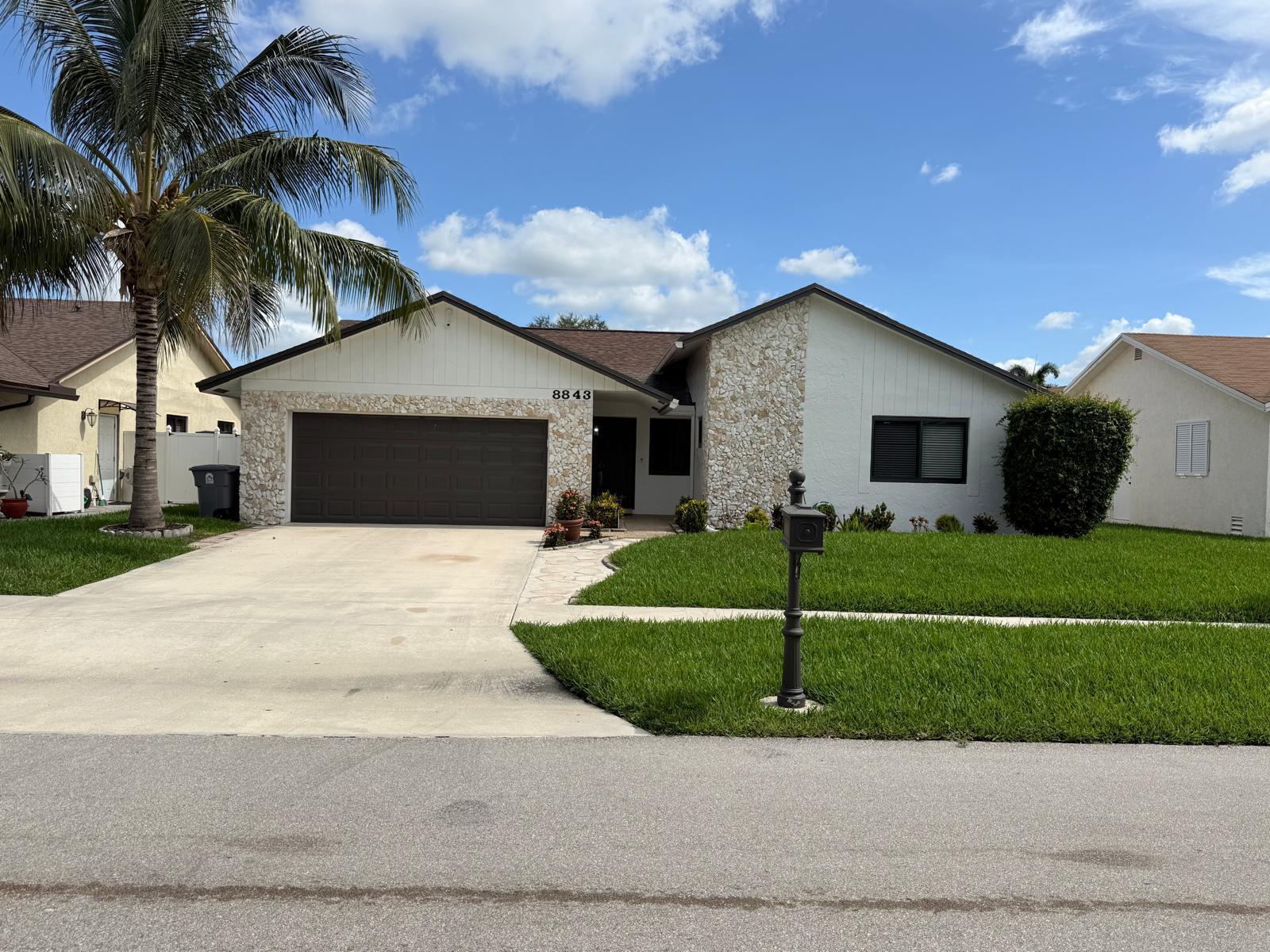 A single-story house with a stone facade, white siding, a brown garage door, and palm tree — 8843 SW 16th Street, Boca Raton FL 33433, BOCA RATON, FL