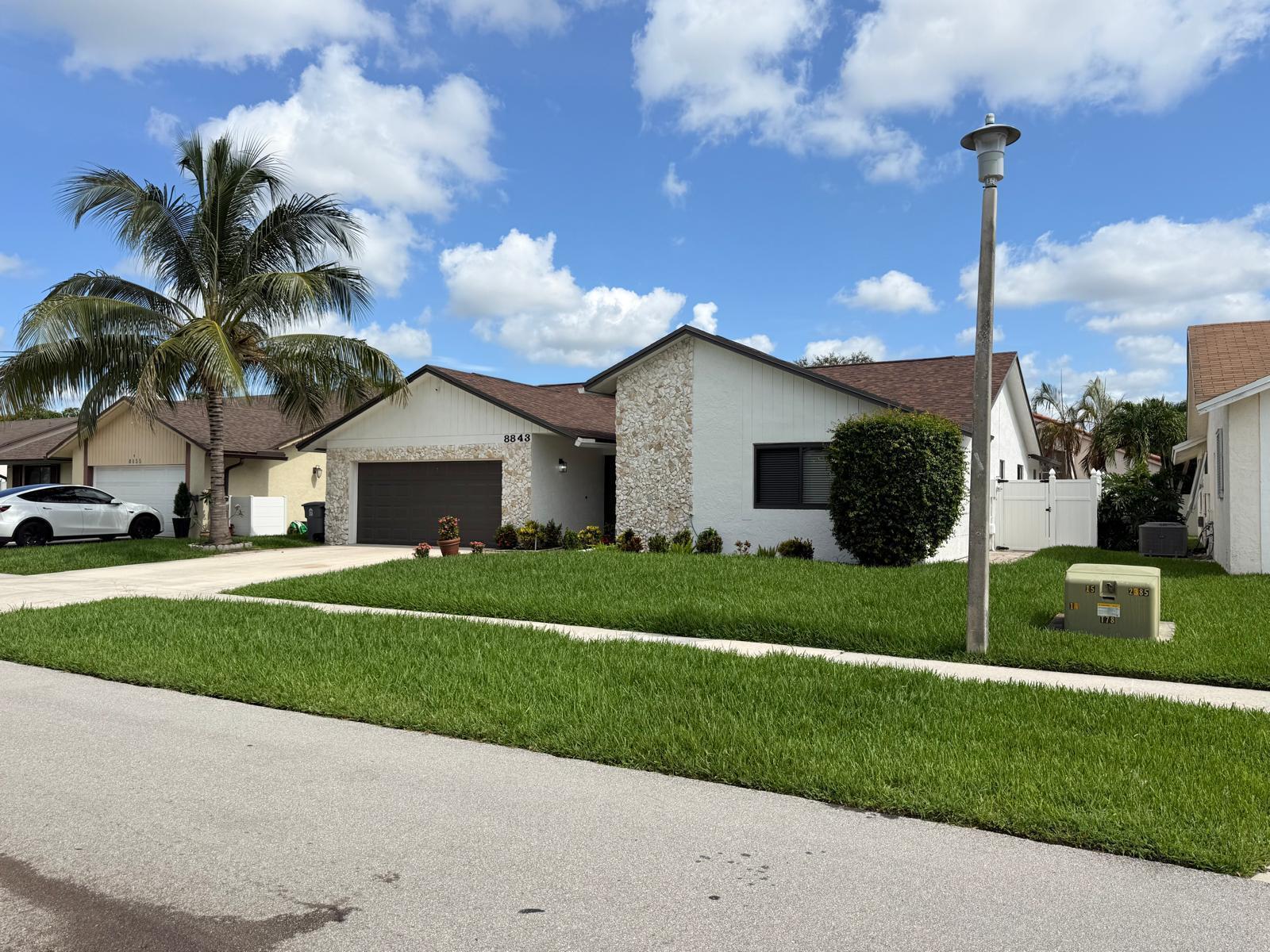 A single-story house features a white exterior with stone accents, a garage, and a palm tree — 8843 SW 16th Street, Boca Raton FL 33433, BOCA RATON, FL