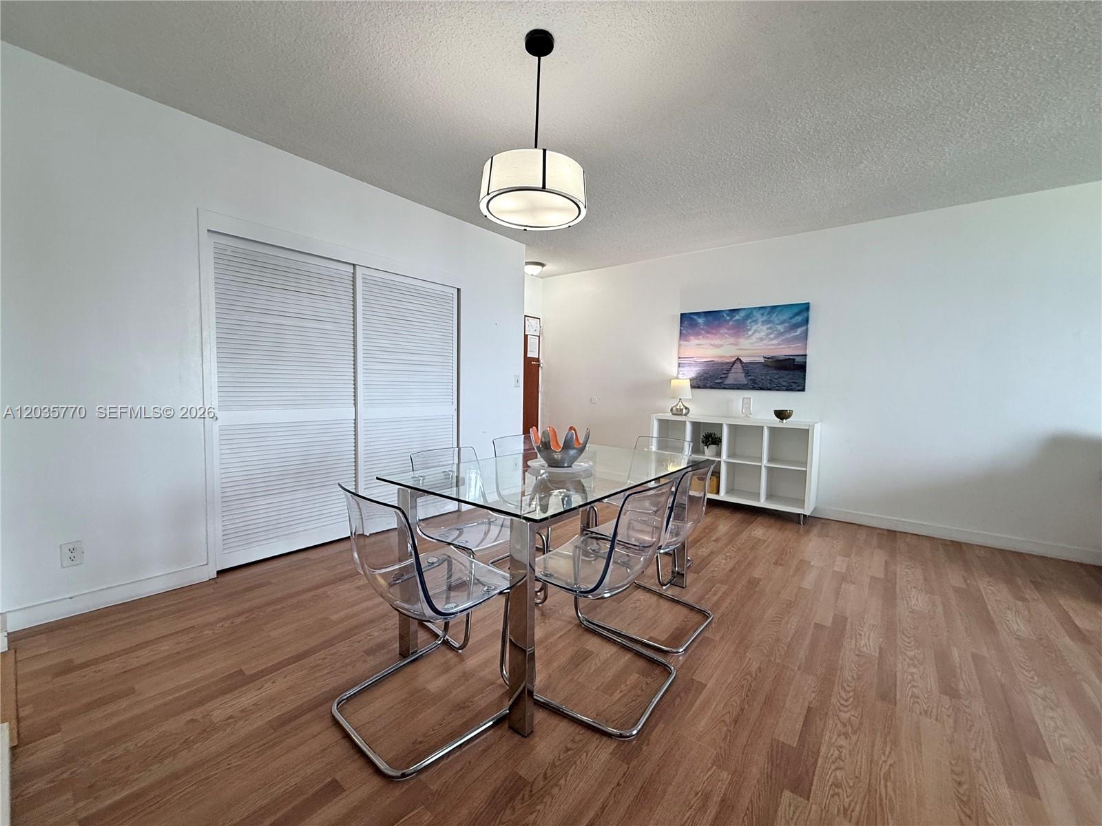 A dining room features a glass table, clear chairs, a pendant light, and wood flooring — 3901 S Ocean Dr # 14U, Hollywood FL 33019, HOLLYWOOD, FL