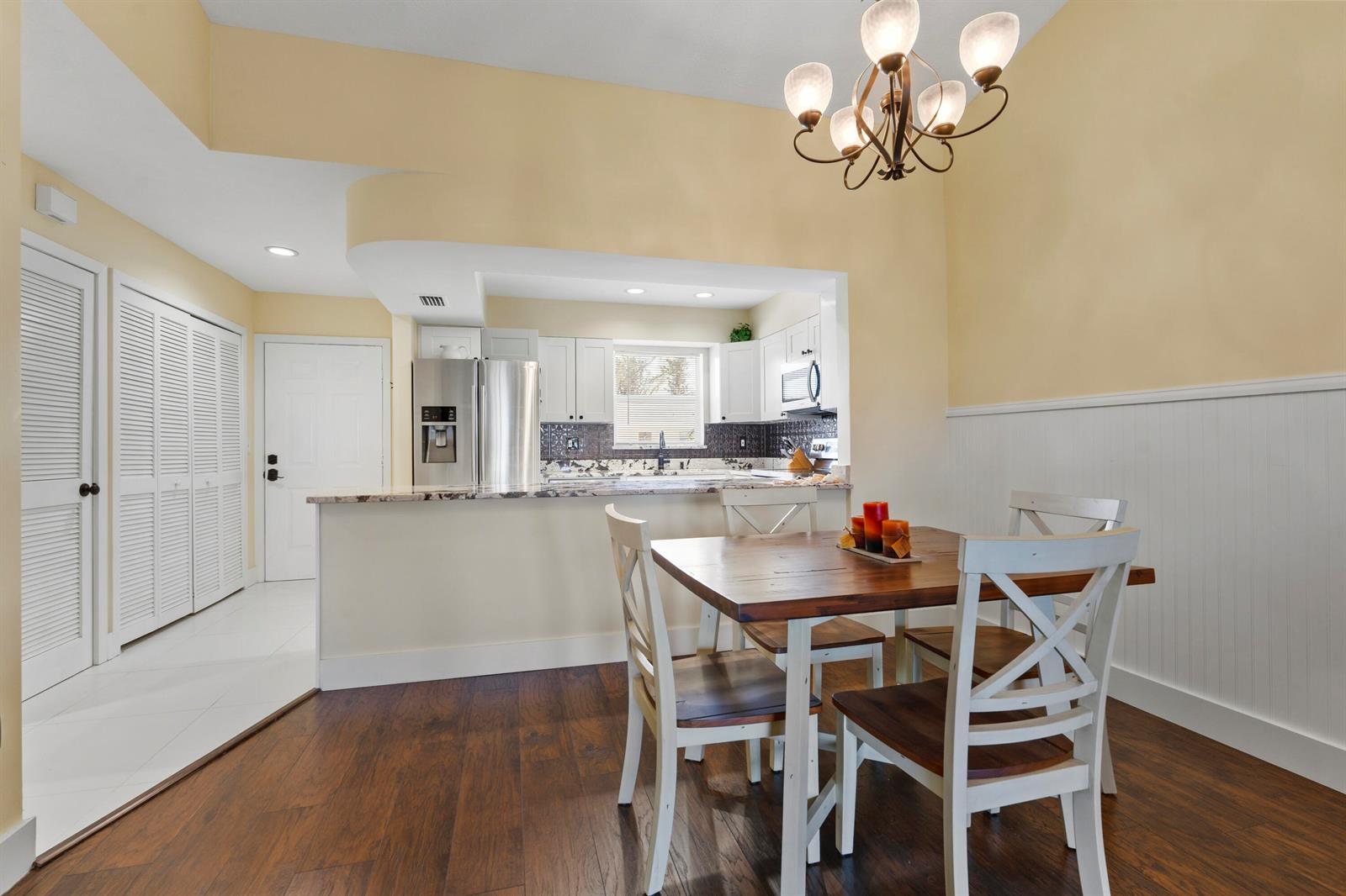 A dining area with a wooden table and chairs sits adjacent to a kitchen — 2950 SE Ocean Boulevard # 6, Stuart FL 34996, STUART, FL