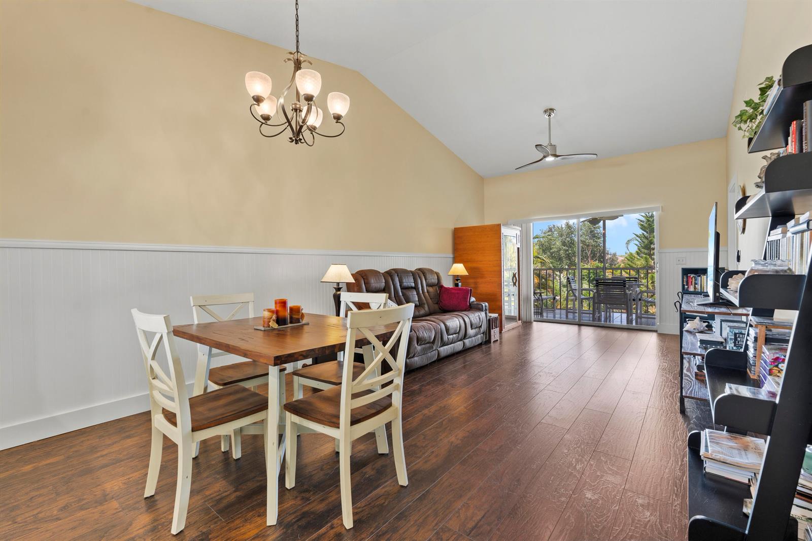 A dining area and living space with wood floors, vaulted ceilings, and a sliding glass door — 2950 SE Ocean Boulevard # 6, Stuart FL 34996, STUART, FL
