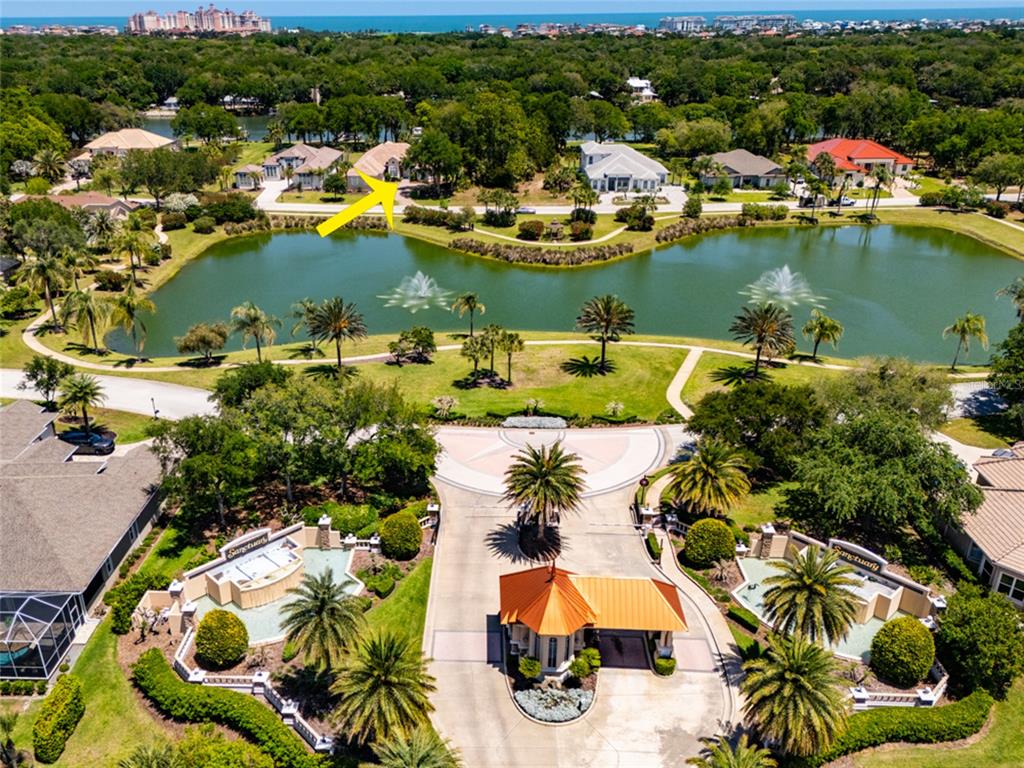 An aerial view shows a gated community entrance with a lake and several houses — 66 OLD OAK DRIVE S, PALM COAST, FL