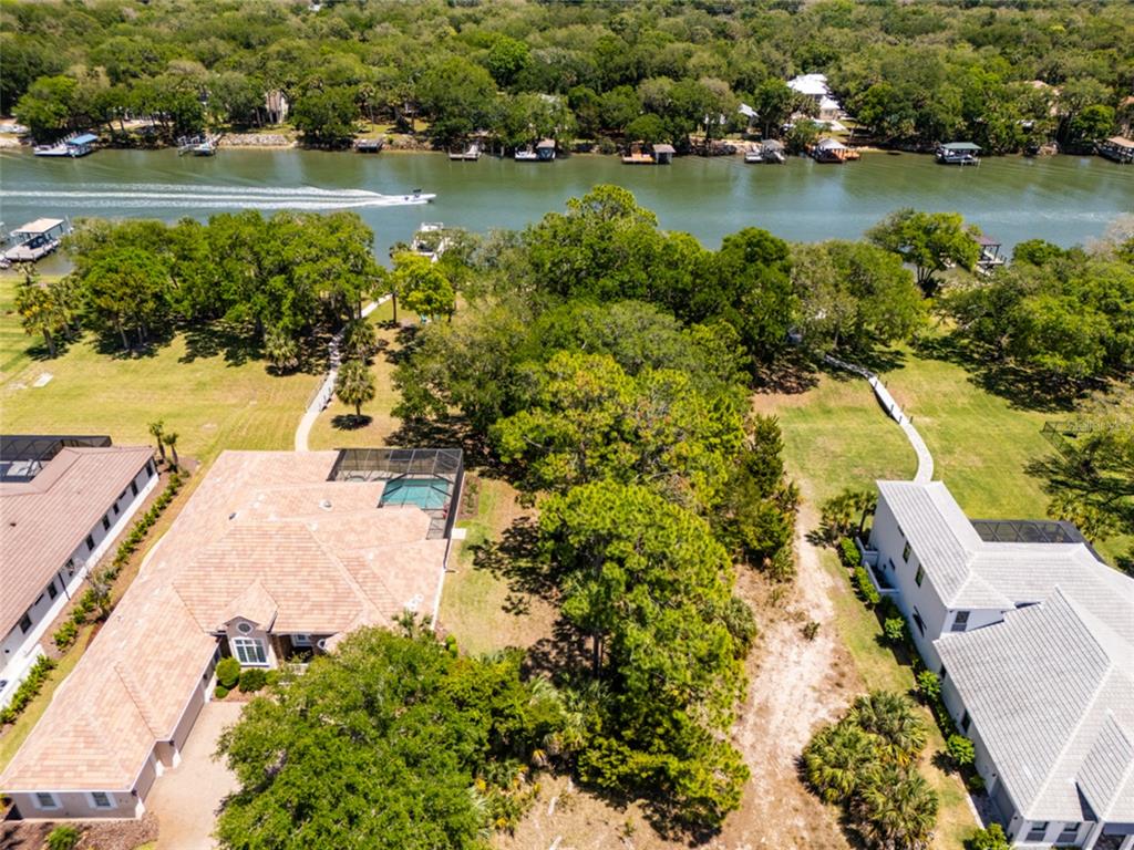 An aerial view shows two houses with pools and private docks along a river — 66 OLD OAK DRIVE S, PALM COAST, FL