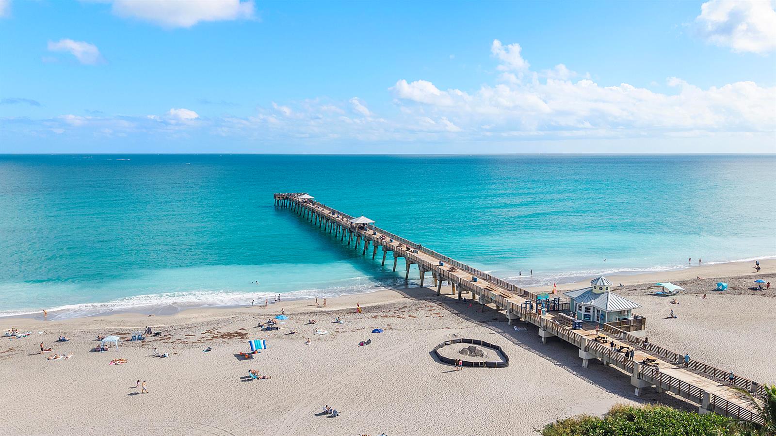 An aerial view shows a long wooden pier extending into the turquoise ocean from a beach — 4161 S Us Highway 1 # G1, Jupiter FL 33477, JUPITER, FL
