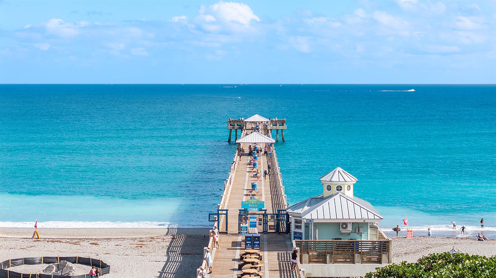 A long wooden pier extends into the turquoise ocean from a sandy beach — 4161 S Us Highway 1 # G1, Jupiter FL 33477, JUPITER, FL