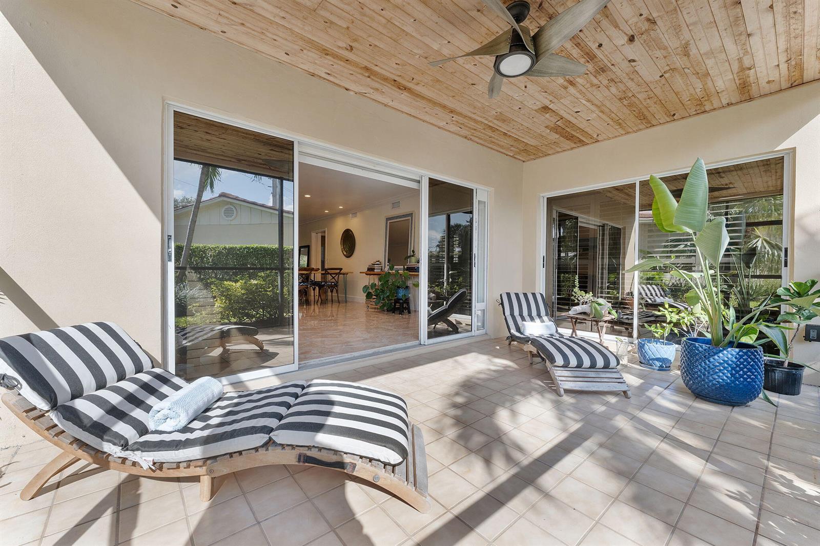 A covered patio features tiled flooring, a wood-paneled ceiling, and two striped lounge chairs — 4161 S Us Highway 1 # G1, Jupiter FL 33477, JUPITER, FL