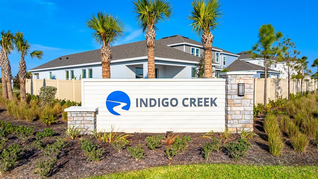 A white sign with the Indigo Creek logo stands before a house and palm trees — 846 STEEL DRIVE, APOLLO BEACH, FL