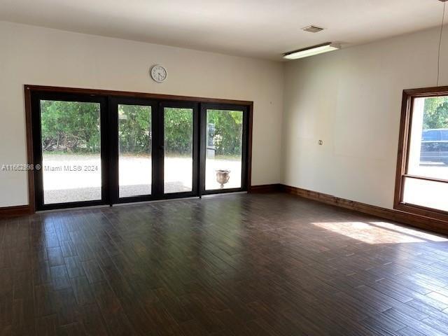 A spacious room features dark wood-look tile flooring, large glass doors, and a window — 4450 S Jog Road, FL 33467, FL