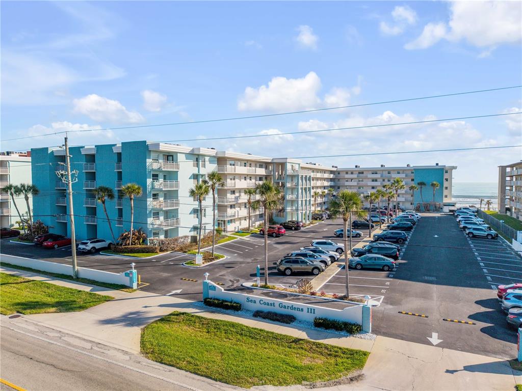 An exterior view of the Sea Coast Gardens III apartment complex with a parking lot — 4153 S ATLANTIC AVENUE UNIT 1170, NEW SMYRNA BEACH, FL